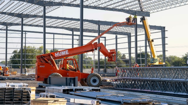 Crane and forklift raising structural steel